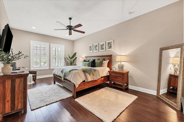 bedroom featuring ceiling fan, dark wood-type flooring, and a textured ceiling