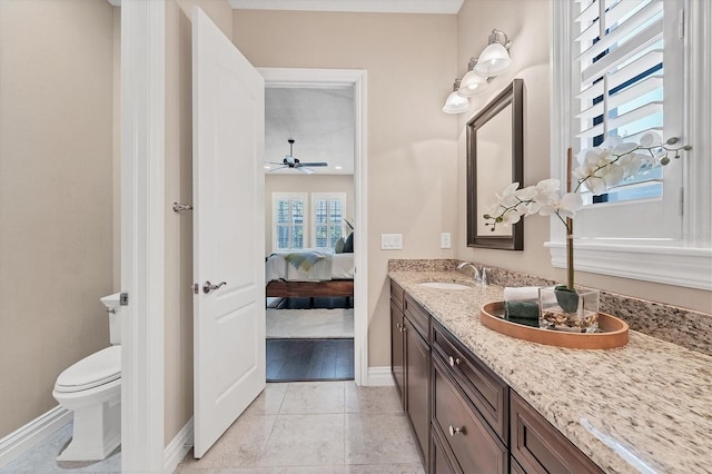 bathroom featuring ceiling fan, tile floors, toilet, and dual bowl vanity