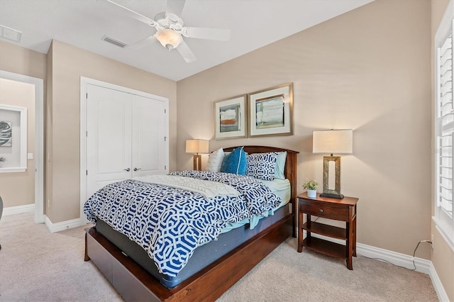 bedroom featuring ceiling fan, light carpet, and a closet