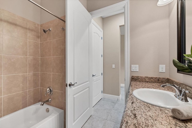 bathroom featuring tile floors, vanity, and tiled shower / bath