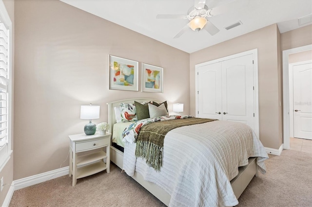 bedroom featuring ceiling fan, a closet, and light carpet