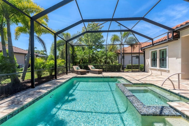 view of swimming pool featuring an in ground hot tub, a patio, and a lanai