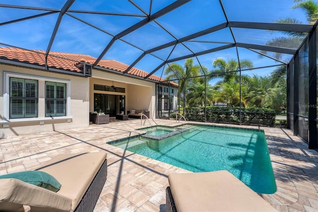 view of pool with glass enclosure, a patio area, ceiling fan, and an in ground hot tub