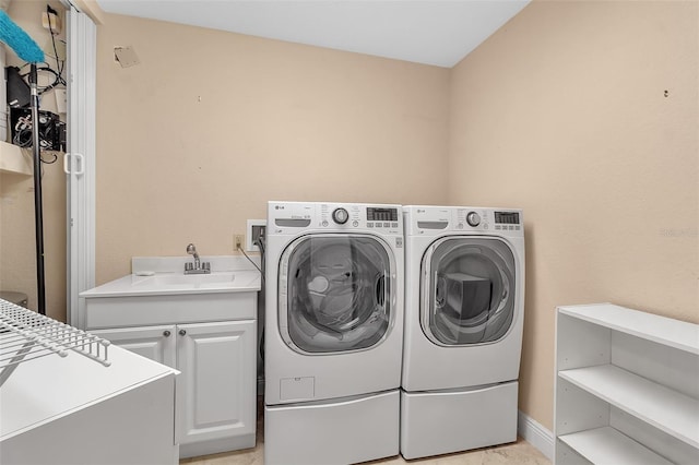 laundry room featuring washing machine and dryer, sink, and cabinets