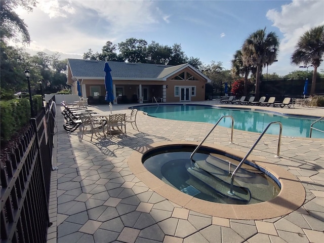 view of swimming pool featuring a patio and a hot tub