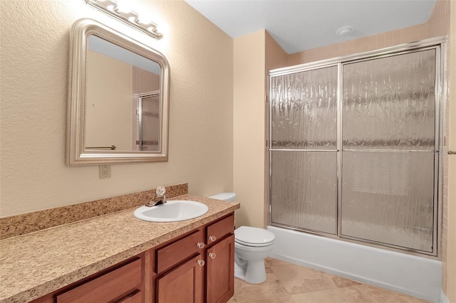 full bathroom with vanity, toilet, and shower / bath combination with glass door