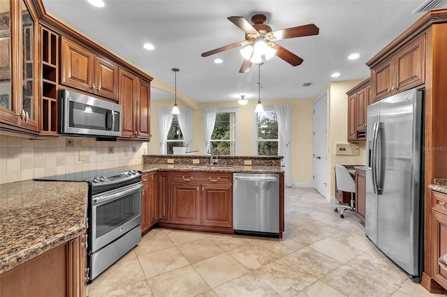 kitchen featuring tasteful backsplash, dark stone counters, pendant lighting, and appliances with stainless steel finishes