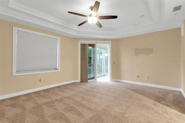 carpeted empty room with a tray ceiling, ceiling fan, and crown molding