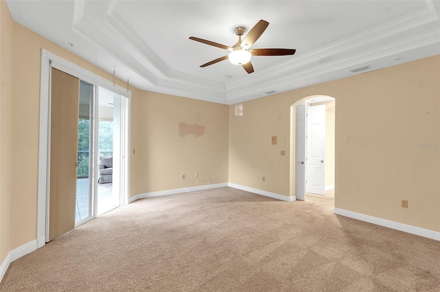 spare room featuring ornamental molding, a tray ceiling, ceiling fan, and light colored carpet