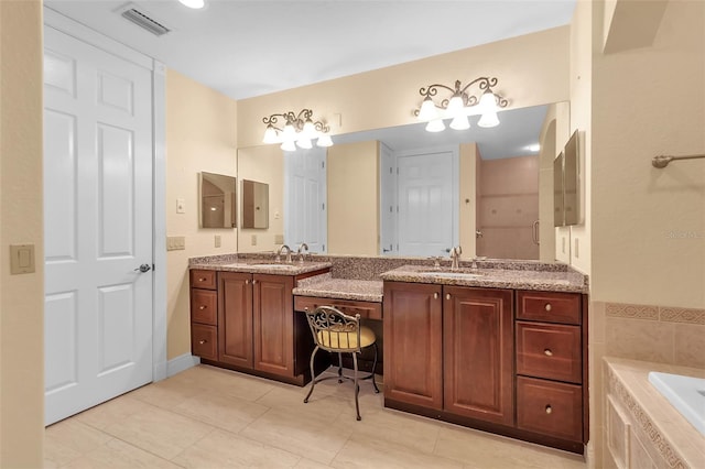 bathroom with tiled bath, tile patterned flooring, and vanity