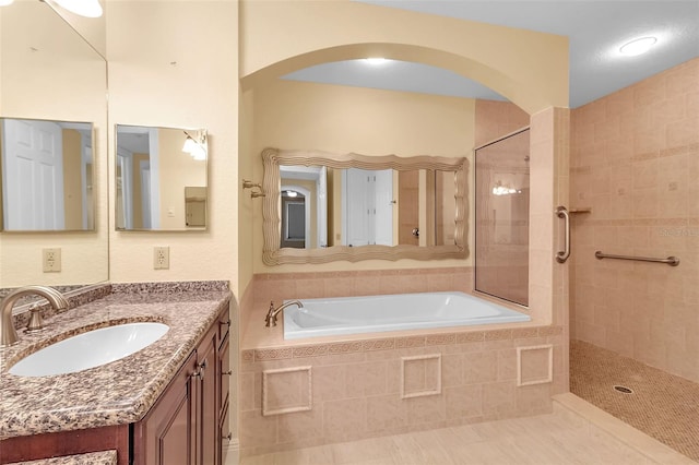 bathroom featuring shower with separate bathtub and vanity