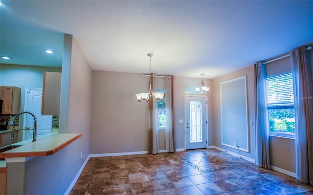 entrance foyer featuring baseboards and a chandelier