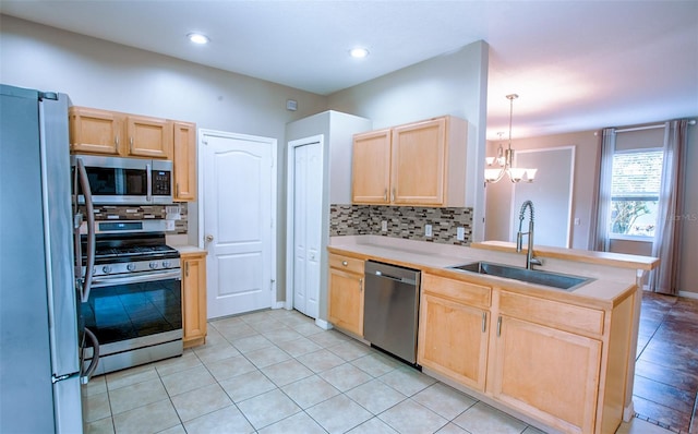 kitchen with appliances with stainless steel finishes, backsplash, a sink, and light brown cabinetry