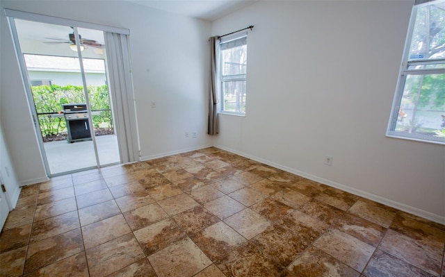 spare room with ceiling fan and baseboards