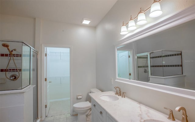 bathroom featuring double vanity, a sink, a walk in closet, and a shower stall