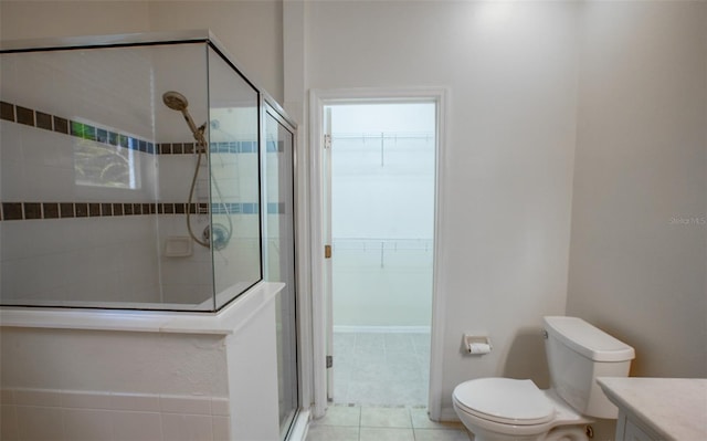 full bathroom featuring a spacious closet, toilet, vanity, a shower stall, and tile patterned floors