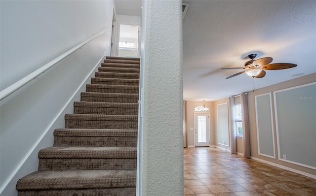 stairs featuring ceiling fan, tile patterned flooring, and baseboards