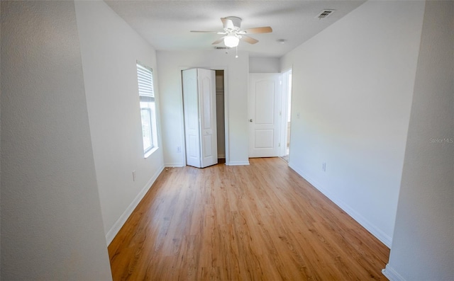 unfurnished bedroom featuring light wood-style floors, visible vents, baseboards, and a closet