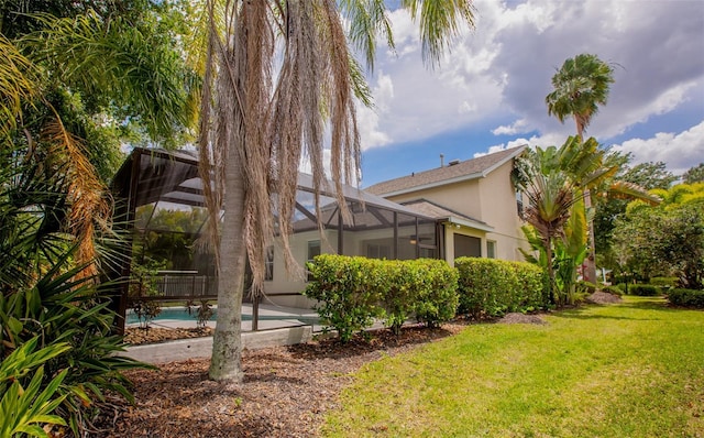 view of yard featuring glass enclosure and an outdoor pool