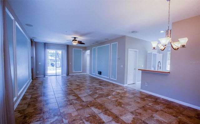 unfurnished living room with baseboards, visible vents, and ceiling fan with notable chandelier