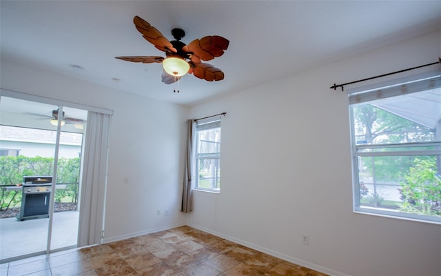 empty room featuring ceiling fan and baseboards