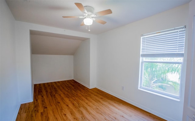 additional living space with a ceiling fan, lofted ceiling, baseboards, and wood finished floors