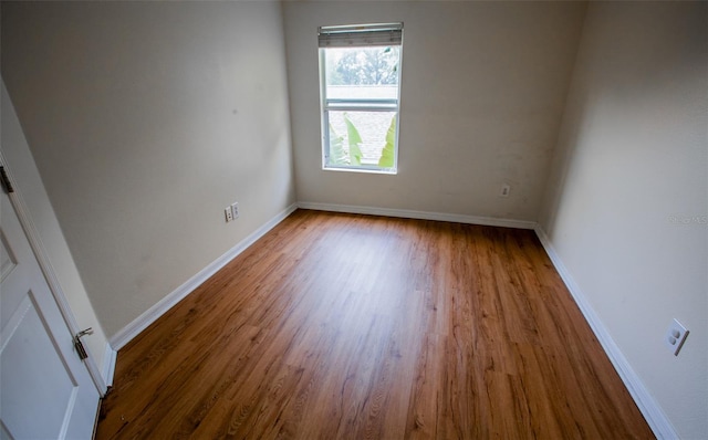 unfurnished room featuring baseboards and wood finished floors