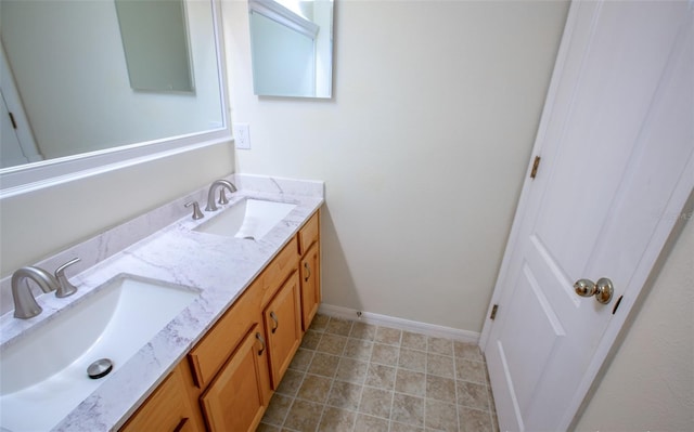 full bathroom featuring double vanity, a sink, and baseboards