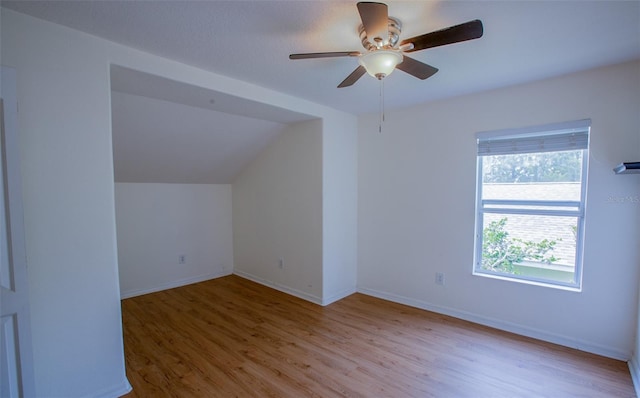 additional living space featuring lofted ceiling, ceiling fan, baseboards, and wood finished floors