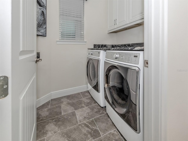 clothes washing area with cabinets and washer and dryer