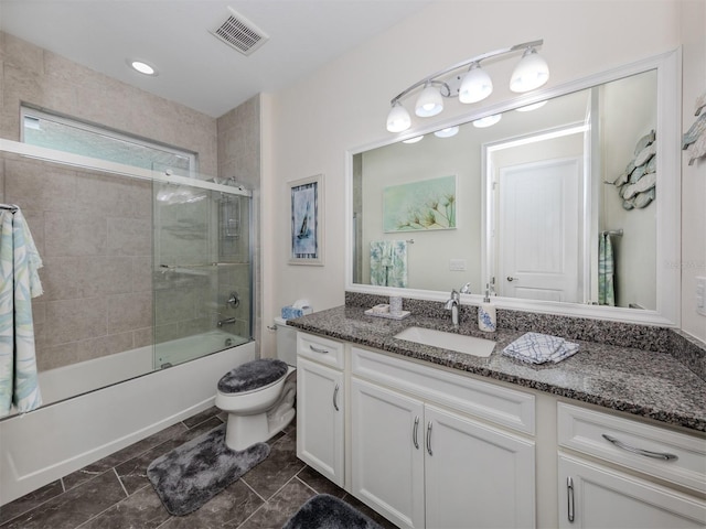 full bathroom featuring vanity, enclosed tub / shower combo, and toilet