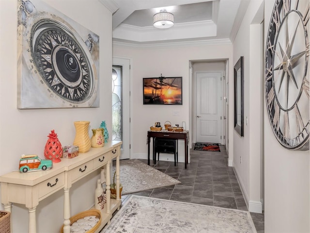 hall with ornamental molding and a tray ceiling