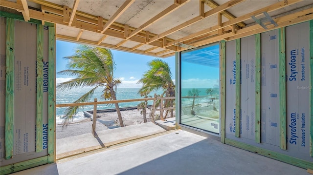 unfurnished sunroom featuring a water view