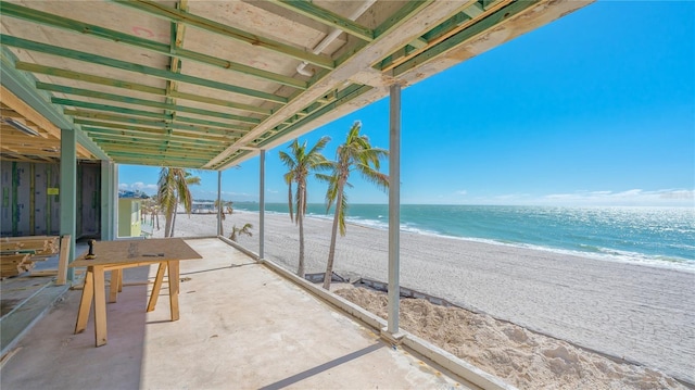 view of patio featuring a water view and a beach view