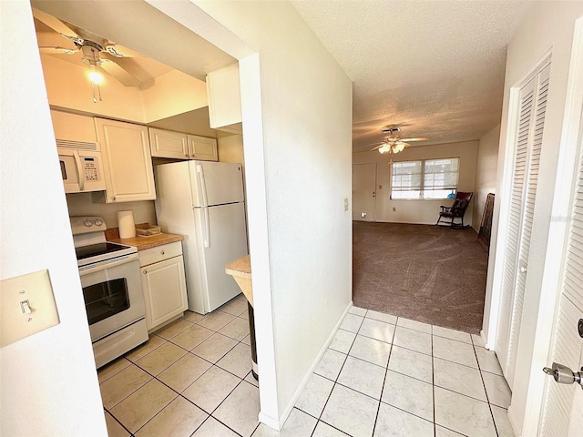 kitchen with light tile floors, ceiling fan, white appliances, and a textured ceiling