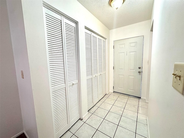 interior space with light tile floors and a textured ceiling