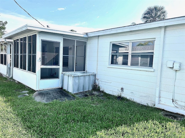 back of house featuring a sunroom and a yard