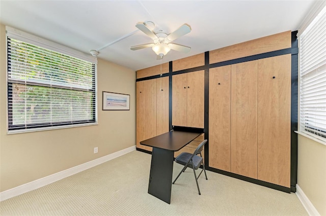 home office featuring light carpet and ceiling fan