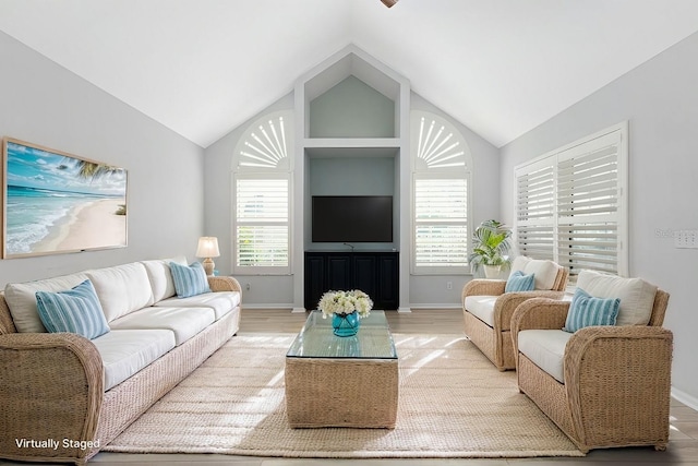 living room with hardwood / wood-style flooring, plenty of natural light, and vaulted ceiling