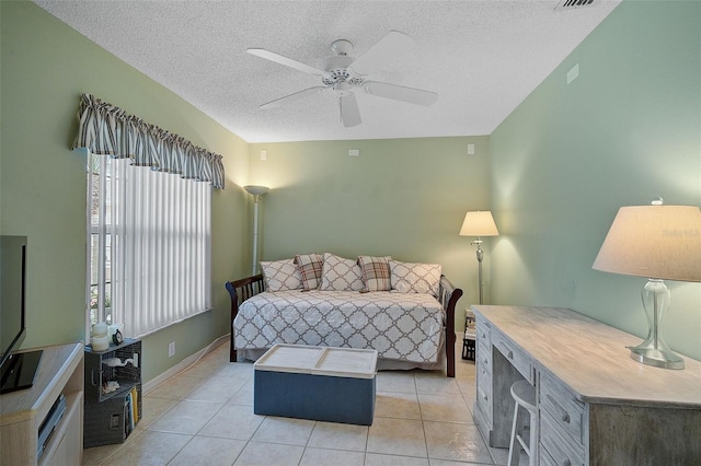 bedroom with ceiling fan, a textured ceiling, and light tile floors