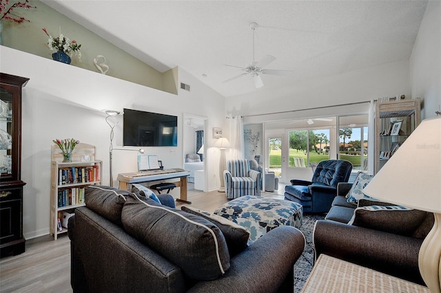 living room with high vaulted ceiling, ceiling fan, and light wood-type flooring