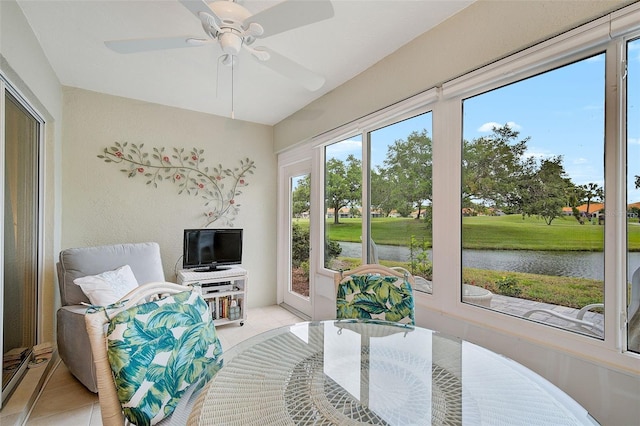 sunroom / solarium featuring ceiling fan and a water view