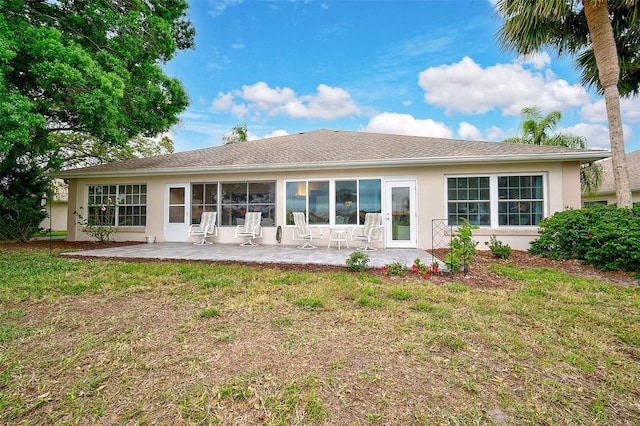 rear view of house with a lawn and a patio area