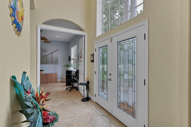 foyer with a towering ceiling and light tile floors