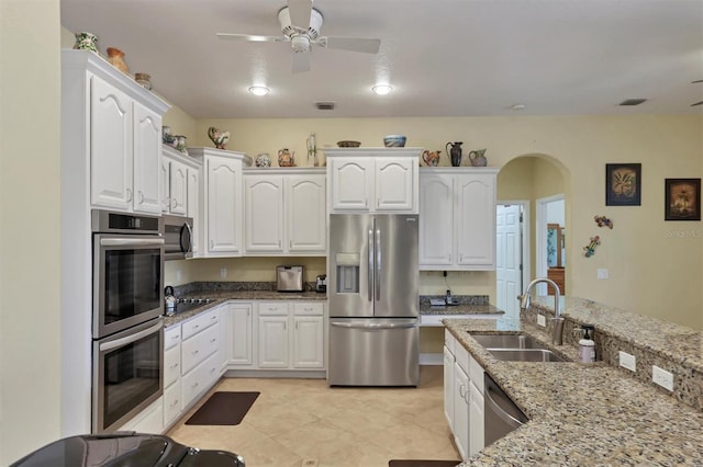 kitchen featuring appliances with stainless steel finishes, light tile flooring, white cabinetry, and ceiling fan