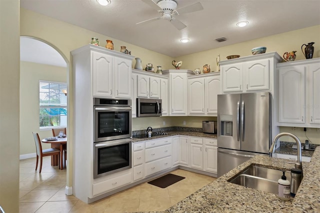 kitchen featuring ceiling fan, stainless steel appliances, white cabinetry, and light stone counters