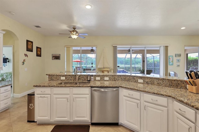 kitchen with plenty of natural light, dishwasher, white cabinets, and stone countertops