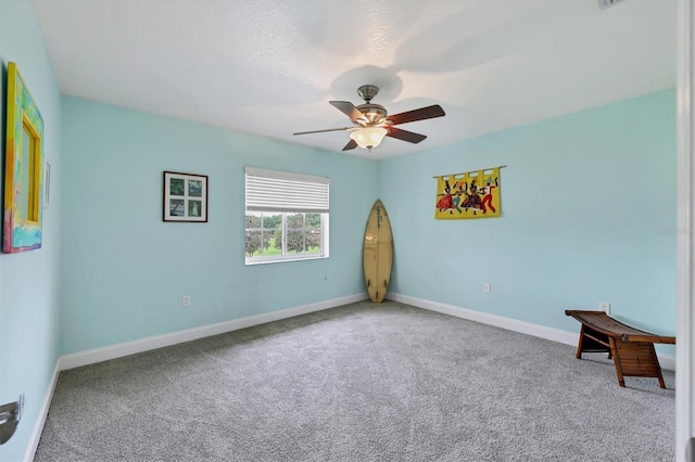 spare room featuring light carpet, ceiling fan, and a textured ceiling