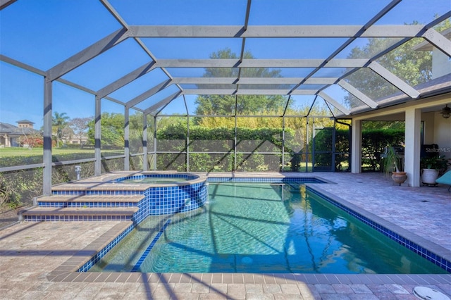 view of pool featuring a patio, glass enclosure, an in ground hot tub, and ceiling fan