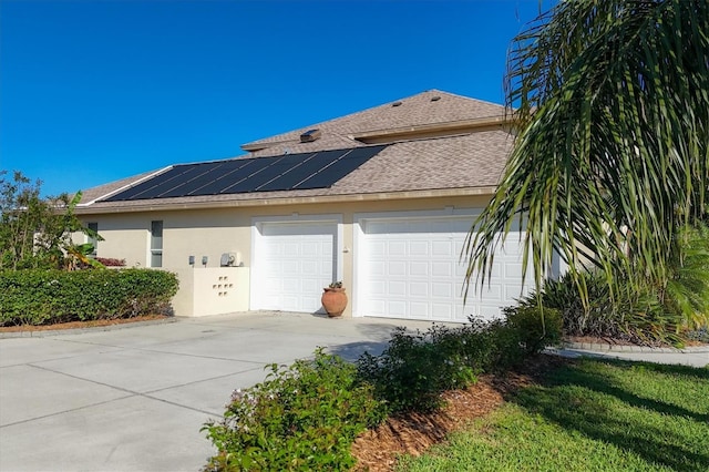 view of property exterior with solar panels and a garage